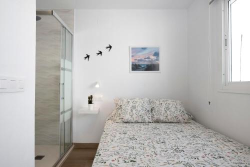 a bedroom with a bed with birds on the wall at Atico Juani in Conil de la Frontera