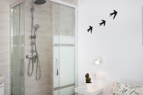 a bathroom with a shower with birds on the wall at Atico Juani in Conil de la Frontera