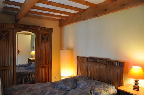 a bedroom with a bed with a wooden headboard and a mirror at Haras de la fontaine Datcha in Poligny