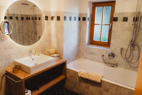 a bathroom with a sink and a tub and a mirror at Apartment Andreas - Gallhof in Vollan