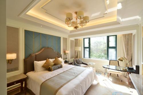 a bedroom with a large bed and a table at Xijiao State Guest Hotel in Shanghai