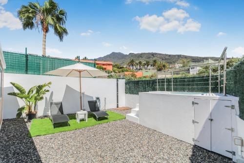 a patio with two chairs and an umbrella at Casa Hoya de Carta in Candelaria