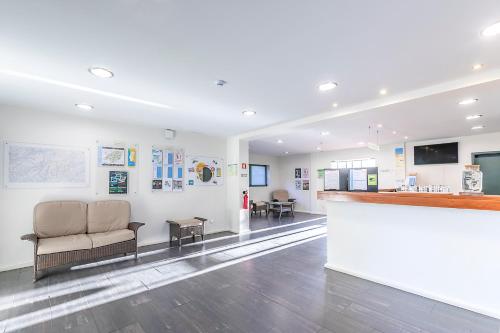 a waiting room with a couch and a bar at HI Geres - Pousada de Juventude do Gerês in Geres