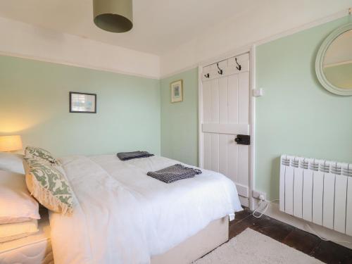 a bedroom with a white bed and a mirror at Glanrafon in Llwyngwril