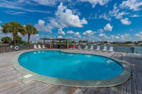 a large swimming pool on a deck with a blue sky at Lei Lani 108 condo in Orange Beach