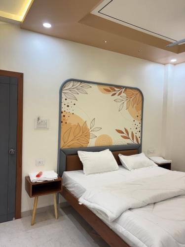 a bedroom with a bed with a large headboard at Hotel Amora in Dighori Buzurg