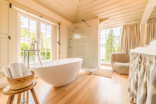 a bathroom with a tub and a large window at Villa Alegria in Azeitao