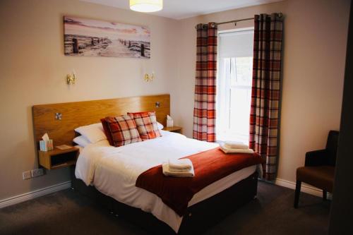 a bedroom with a large bed and a window at Central Bar Guesthouse in Cushendall