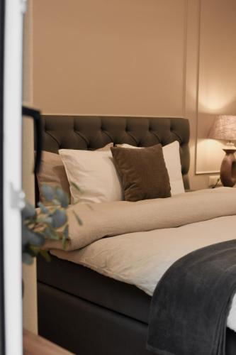 a bed with a headboard with pillows and a lamp at Boutique Vaksali Apartment in Viljandi