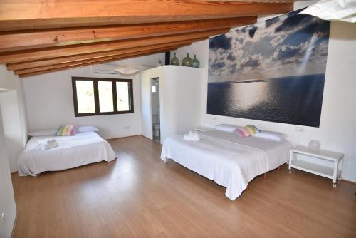 a bedroom with two beds and a large painting on the wall at S'abeurada con piscina en Soller in Sóller