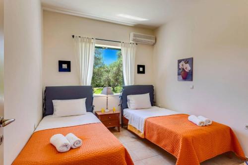 two beds in a room with a window at Villa Anna Maria by Villa Plus in Pírgos Psilonérou