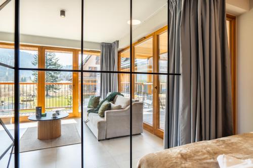 a living room with glass doors and a couch at Mountain Mood by Apart Concept Podhale in Kościelisko