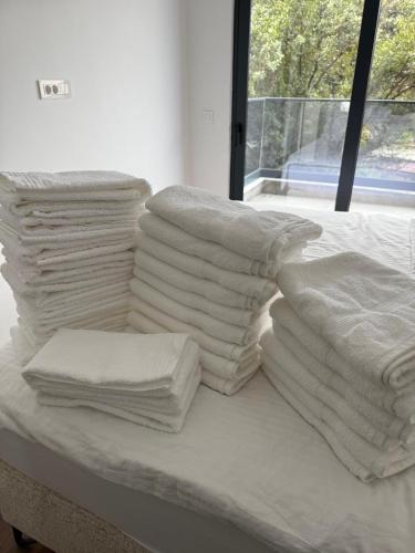 a pile of white towels sitting on a bed at Brillex Swiss Residence in Dobra Voda