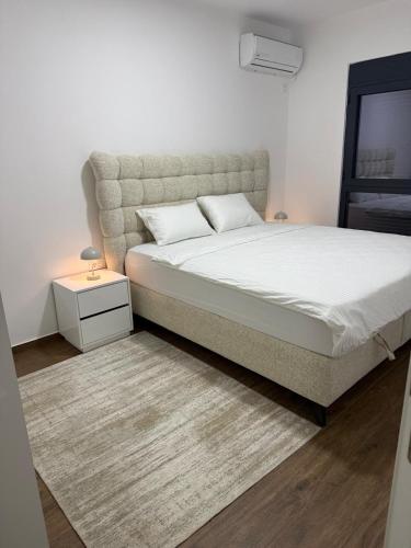 a bedroom with a large bed and a night stand at Brillex Swiss Residence in Dobra Voda