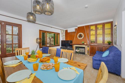 a dining room with a blue table with food on it at Villa El Mal Pas / Can Seguinet in Alcudia