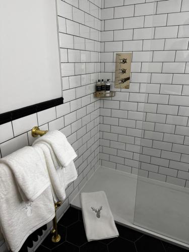 a bathroom with a bath tub and towels on a shelf at The Bellachroy in Dervaig