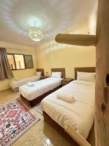 a hotel room with two beds and a chandelier at Green Valley Lodge - Atlas Mountains Nature in Taroudant