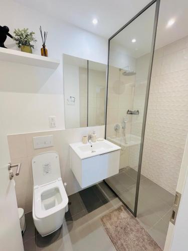 a bathroom with a toilet and a sink and a shower at Nomah Homes The Bantree in Accra