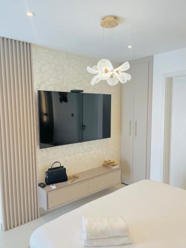 a bedroom with a bed and a tv on a wall at Nomah Homes The Bantree in Accra