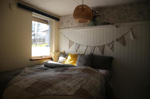 a bedroom with a bed and a window at Schwedisches Waldcottage Fluss & Wanderwege in Fristad
