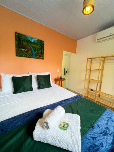 a bedroom with a bed with two towels on it at Pousada Oxente Uai! in Pirenópolis