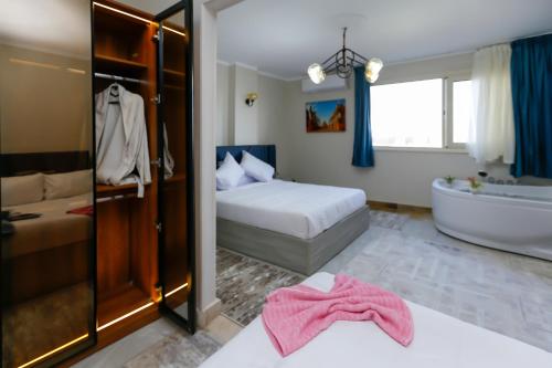 a bedroom with a bed and a bathtub and a bed and a bath tub at locanda pyramids view & Jacuzii in Cairo