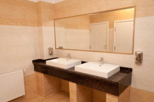 a bathroom with two sinks and a large mirror at Hotel Hanul de la Rascruce in Arad