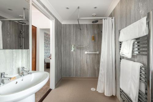 a bathroom with a tub and a sink and a shower at Imperial Lodge in Great Yarmouth
