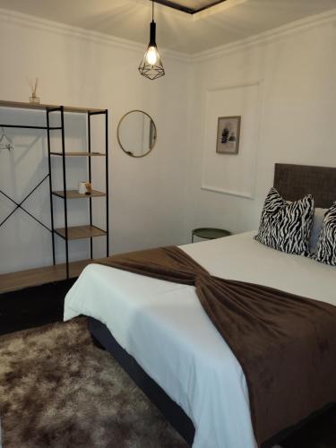a bedroom with a large bed and a shelf at Villa Tlhago Lodge in Ga-Mothapo