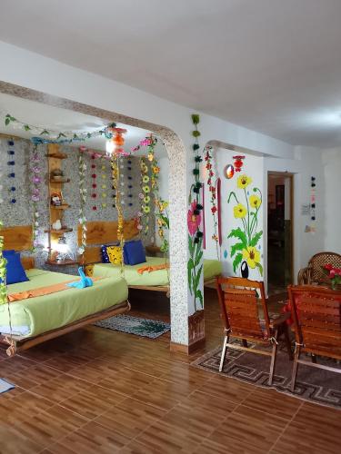 a living room with a couch and chairs and flowers on the walls at Jardín Andino Hostal in Copacabana