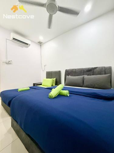 a bedroom with a large blue bed with yellow pillows at The Single Level Bliss By Nestcove in Malacca