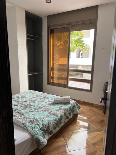 a bedroom with a bed and a window at Guest house in Imsouane