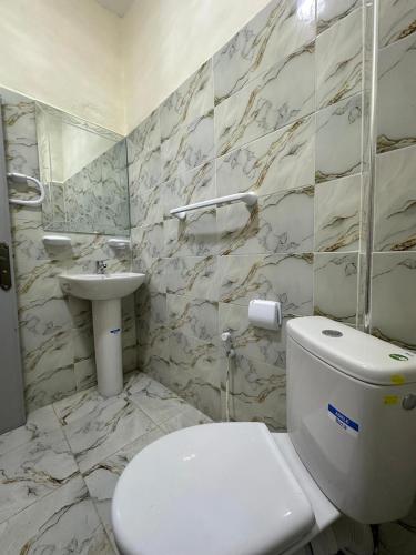 a bathroom with a white toilet and a sink at Green Valley Lodge - Atlas Mountains Nature in Taroudant