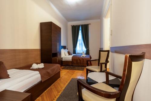 a hotel room with two beds and a table and chairs at Central Hotel 21 in Budapest