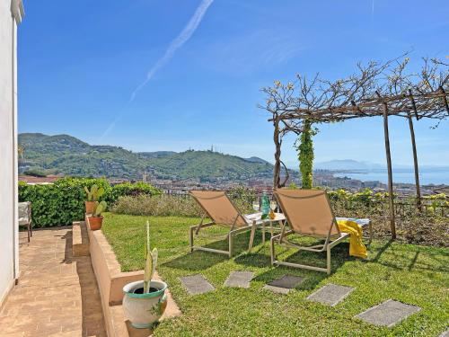 a patio with two chairs and a pergola at Villa Ipomea - Terra Suite in Salerno