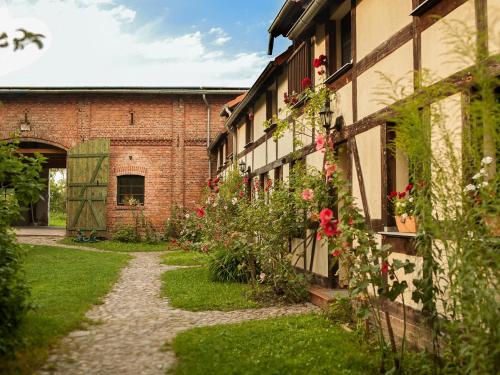 ein Backsteingebäude mit Blumen an der Seite in der Unterkunft Behringhof in Leuenberg