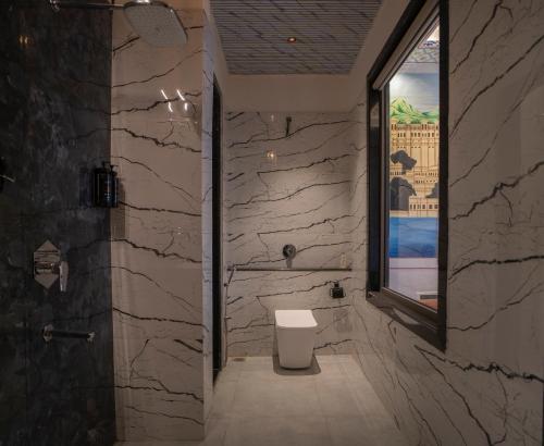 a stone bathroom with a toilet and a window at UDAISA - The Luxury Art in Udaipur
