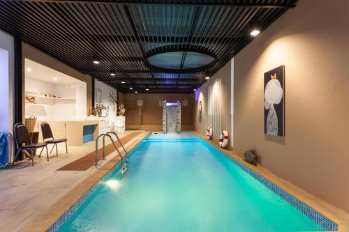 a large swimming pool in a room with a swimming pool at We Briza Hotel Chiangmai in Chiang Mai