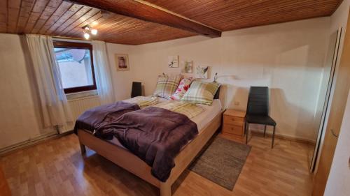 a bedroom with a bed and a table and a window at Ferienwohnung Altrichter in Wabern