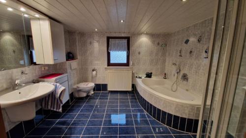 a bathroom with a tub and a sink and a toilet at Ferienwohnung Altrichter in Wabern