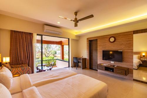 a bedroom with a bed and a flat screen tv at The International Centre Goa in Panaji