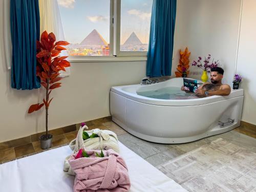 a man sitting in a bath tub in a bathroom at locanda pyramids view & Jacuzii in Cairo