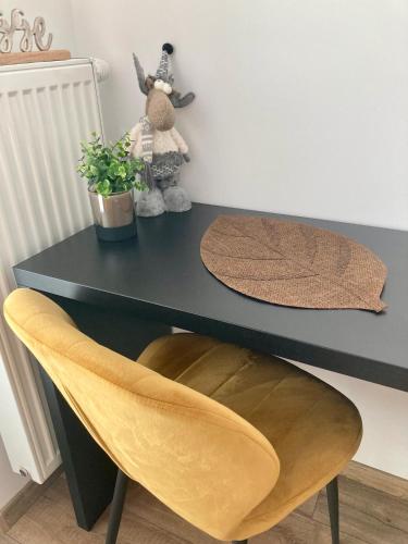 a black desk with a yellow chair and a black table at Apartment Poprad in Poprad