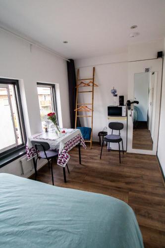 a room with a bed and a table and chairs at Bed and Breakfast Amsterdam Holy Dove in Amsterdam