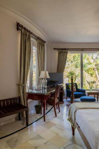 a bedroom with a desk and a table in a room at Barwara Kothi in Jaipur