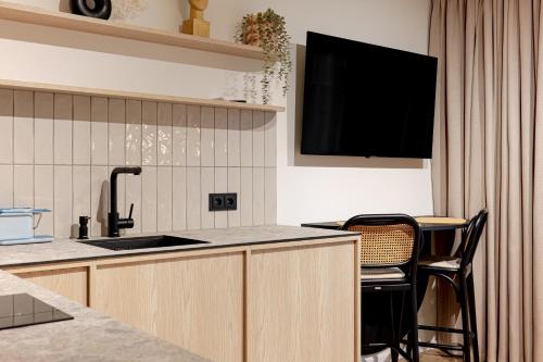 a kitchen with a sink and a tv on the wall at Sunny Hill in Palanga