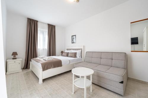 a bedroom with a bed and a couch and a table at Hotel Podostrog - New Comfort 2026 in Budva