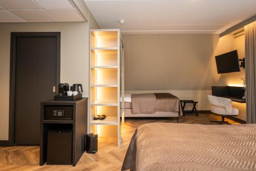 a bedroom with a bed and a room with a bed gmaxwell gmaxwell at Hotel het Uilenbos in De Koog