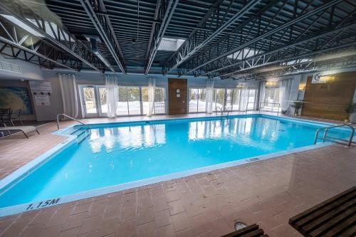 a large indoor swimming pool with blue water at Modern Condo with Pool - Le Rendez-Vous in Beaupré