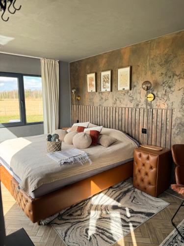 a bedroom with a large bed in a room at Retrīts MIGLA with sauna included in Stacija )) (( Blukas
